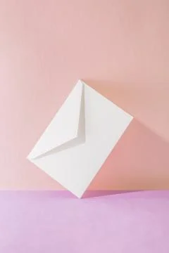 An envelope in a pink two-tone background. Stock Photos