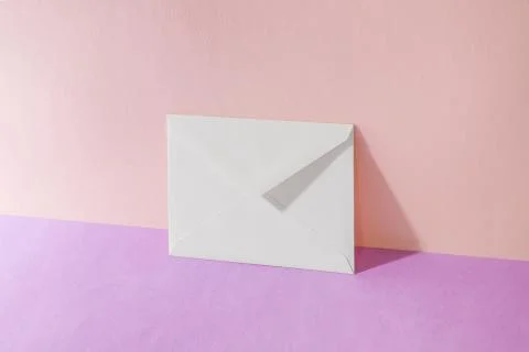 An envelope in a pink two-tone background. Stock Photos