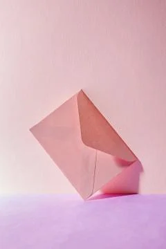 An envelope in a pink two-tone background. Stock Photos