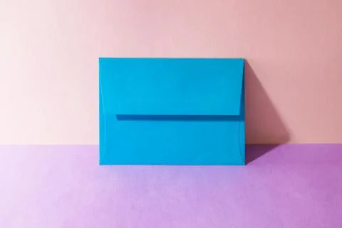 An envelope in a pink two-tone background. Stock Photos