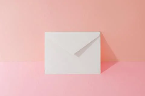 An envelope in a pink two-tone background. Stock Photos