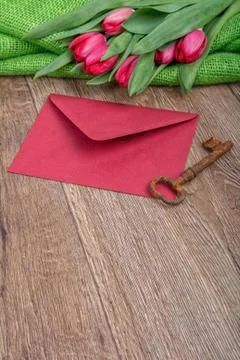 Envelope, rusty key and tulip on a wooden background Foto stock