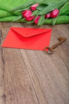 Envelope, rusty key and tulip on a wooden background Foto stock