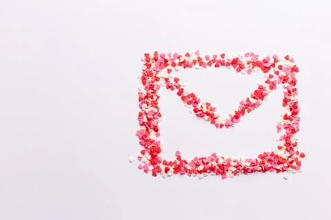 Envelope shape on white background made of red white and pink hearts sweets. Top Stock Photos