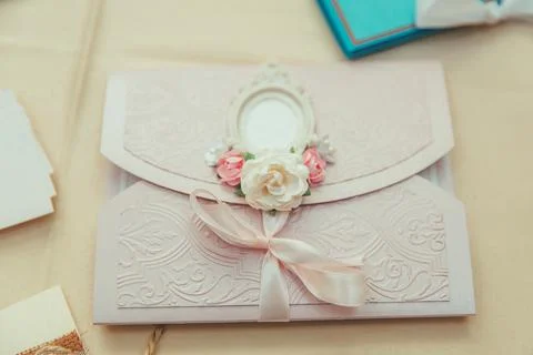 An envelope with soft pink embossing, decorated with a light pink ribbon, art Stock Photos