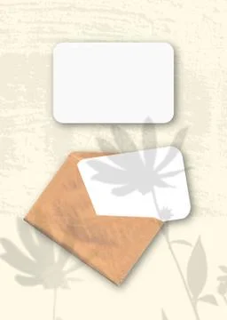 An envelope with two sheets of textured white paper on the yellow background  Stock Photos