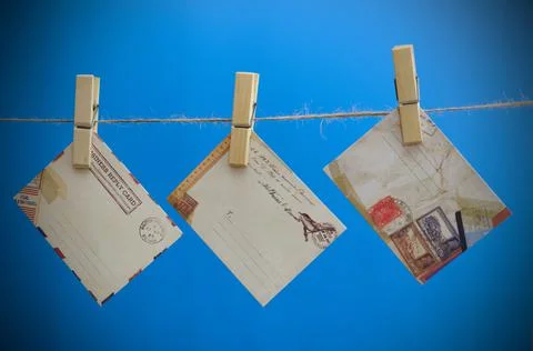 Envelopes of the message on a rope on a blue background. Stock Photos