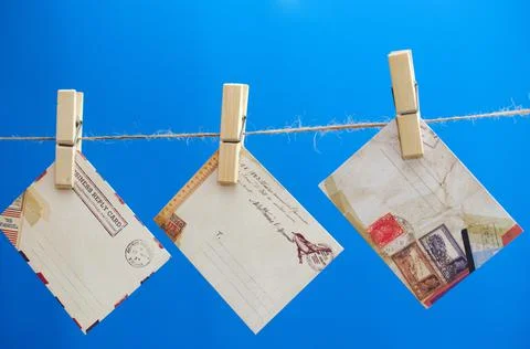 Envelopes of the message on a rope on a blue background. Stock Photos