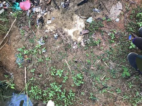 The environment is dirty because of piles of various types of rubbish scattered Stock Photos