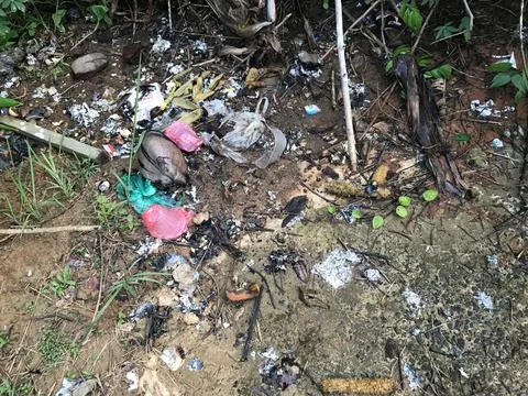The environment is dirty because of piles of various types of rubbish scattered Stock Photos