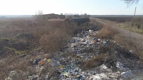 Environment pollution. Piles of garbage thrown along the road in the field. Video stock 165642089