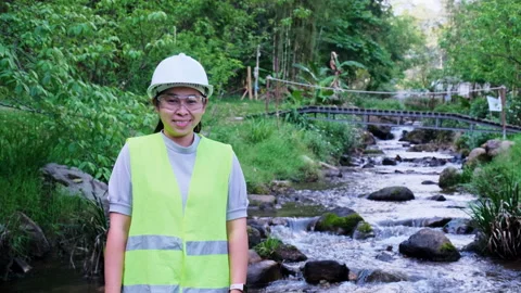 Environmental engineer stands with arms crossed on forest stream background Vídeo Stock 172390365