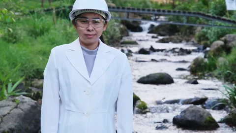 Environmental engineer stands with thumbs-up gesture on forest stream background Видео 172391042