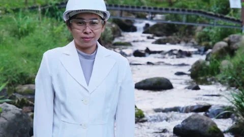 Environmental engineer stands with thumbs-up gesture on forest stream background Vídeos de archivo 172391094