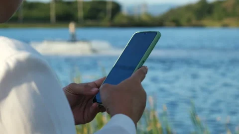 Environmental engineer uses a mobile phone to operate an oxygen turbine aerator. Stock Footage 229704376
