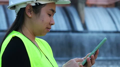 Environmental engineer uses a mobile phone to record water analysis data in dam. Stock Footage 229711810