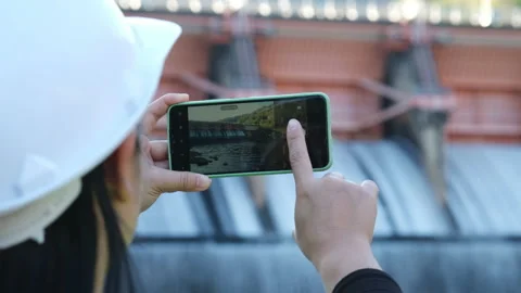 Environmental engineer uses a mobile phone to record data at a dam. Stock Footage 229711943