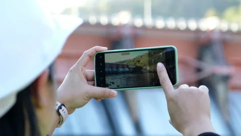 Environmental engineer uses a mobile phone to record data at a dam. Stock-Footage 229714119