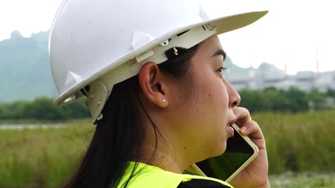 Environmental engineer uses a smartphone near a reservoir against a power plant Stock Footage 276953997