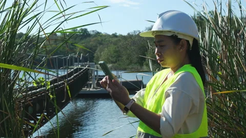 Environmental engineer working with mobile phone at reservoir Stock Footage 229707363