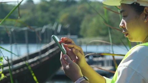 Environmental engineer working with mobile phone at reservoir Stock Footage 229707906