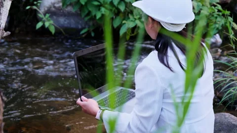 Environmental engineers uses laptop to inspect water quality at natural water. Vídeo Stock 172391117