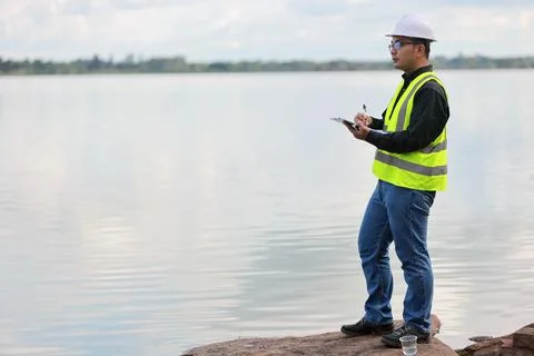 Environmental engineers work at water source to check for contaminants  in .. Stock-Fotos