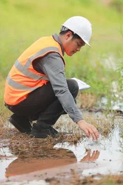 Environmental engineers work at water source to check for contaminants  in .. Stock Photos