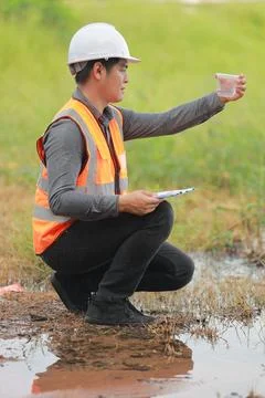Environmental engineers work at water source to check for contaminants  in .. Stock Photos