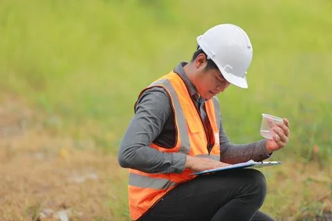 Environmental engineers work at water source to check for contaminants  in .. Stock Photos