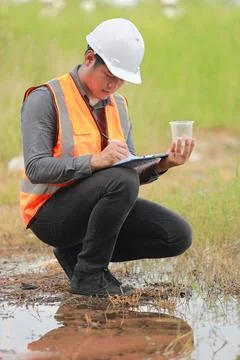 Environmental engineers work at water source to check for contaminants  in .. Stock Photos