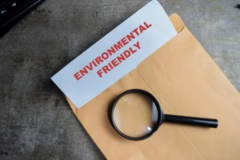 Environmental friendly text on document above brown envelope. Stock Photos