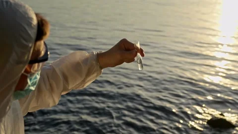Environmental inspector collecting a sample in a test tube, water pollution and Stock Footage 327274191