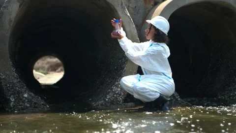 Environmental inspector in protective suit examining wastewater Vídeos de archivo 341333161