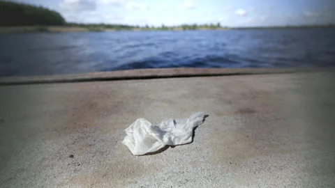 Environmental pollution caused by a discarded tissue on a jetty Stock Footage 204106218