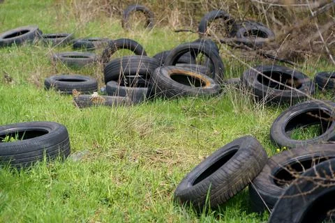 Environmental pollution concept, ecology problem. Tires from car wheels are s Stock Photos