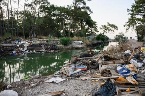 Environmental pollution with plastic and construction waste near a river in Фото
