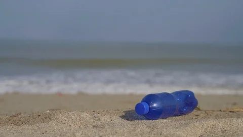 Environmental pollution with a plastic bottle at a beach. 4K Video footage 스톡 동영상 115910376