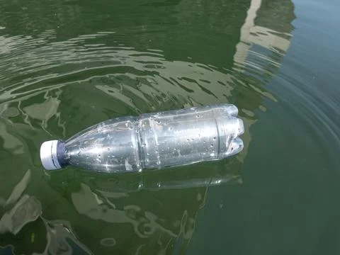 Environmental pollution - plastic bottle floating in sea water in urban city. Foto stock