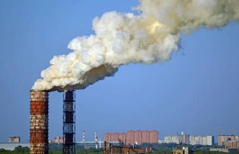 Environmental pollution. Smoke from factory pipes on a background of clear sky Stock Photos