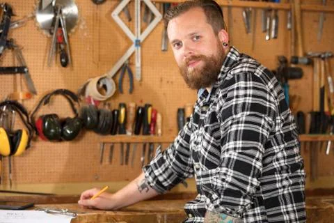 Environmental portrait of a carpenter in workshop Stock Photos