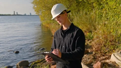 Environmental Scientist Taking Notes During Water Pollution Testing Stock Footage 321865679