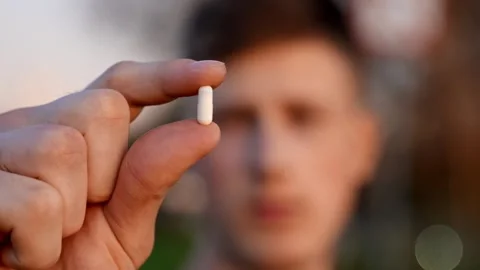 Environmental worker holds tiny object forward for inspection while reviewing Stock Footage 327274102