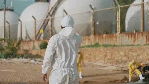 Environmental workers protective suits collect water samples near wastewater 動画素材 343334079