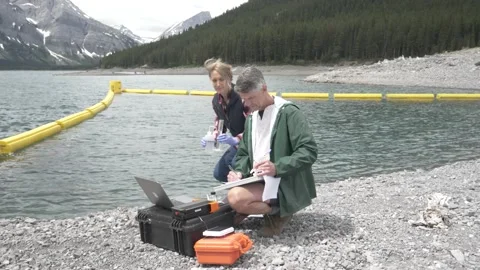 Environmentalists with equipment testing water sample at lake Video stock 221039636