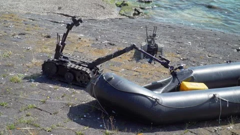 EOD Robot Grabs Yellow Case in Rubber Boat Exercise, Sandy Coast 2021 Video stock 229758010