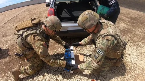 EOD soldiers placing improvised explosive device beneath vehicle Stock Footage 111947858