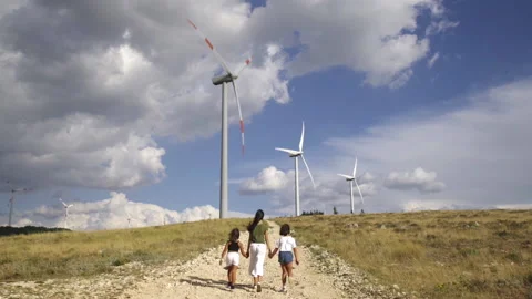 Eolic wind turbines and three young girls Stock Footage 137441702