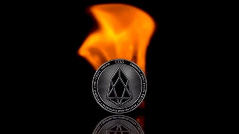 EOS coin catches fire on an isolated black background. Slow motion 250fps. Video stock 154007828