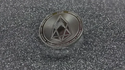 EOS cryptocurrency falls on silver sequins. Stock Footage 155544129